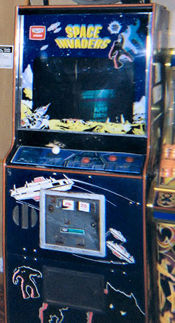 A blue arcade cabinet with a screen surrounded by decals. The game controls sit below the screen, while the phrase 