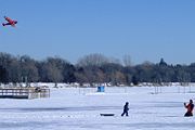People flying kites on Lake Harriet frozen and covered with snow
