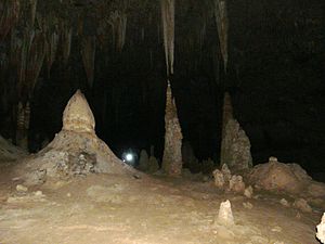 Halah Cave (كهف حالة) east of the island. Stalagmites and stalactites show how high it can reach compared to the 1.7m man with the torch. It is several hundred metres deep, with total darkness.