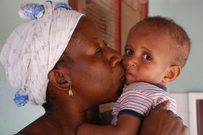 Baby Omar held by mother, Bakoteh, Gambia